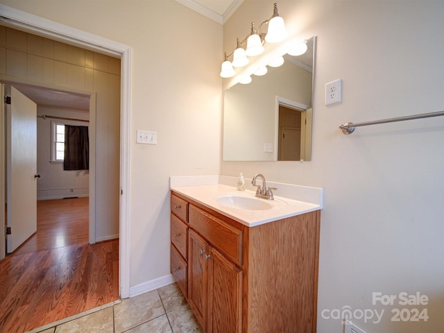 bathroom with crown molding, hardwood / wood-style floors, and vanity