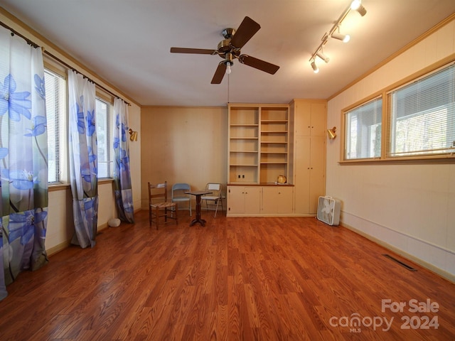 unfurnished room with wood-type flooring, track lighting, ceiling fan, and ornamental molding