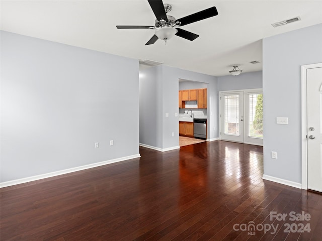 unfurnished living room featuring dark wood-type flooring and ceiling fan