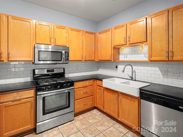 kitchen with sink, appliances with stainless steel finishes, decorative backsplash, and light tile patterned floors