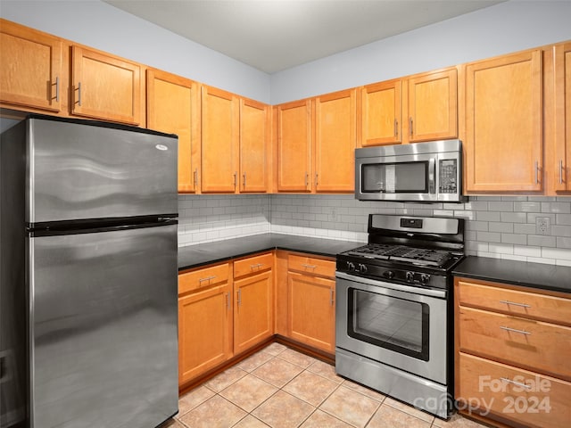 136 Lower Grassy Branch Rd, Asheville, NC 28805 - kitchen featuring appliances with stainless steel finishes, dark countertops, light tile patterned floors, and backsplash