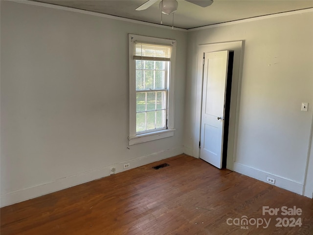 empty room featuring ornamental molding, hardwood / wood-style floors, and ceiling fan