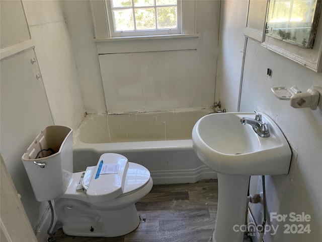 bathroom with wood-type flooring, toilet, and a bath