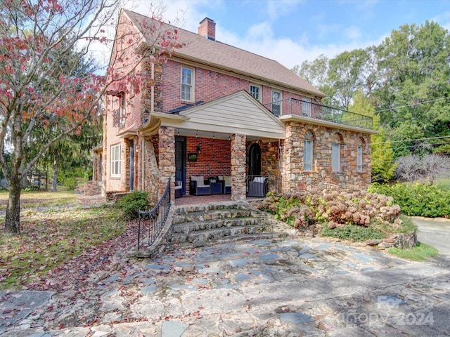 1116 E Franklin Blvd, Gastonia, NC 28054 - view of front facade with a porch, a chimney, stone siding, a balcony, and brick siding