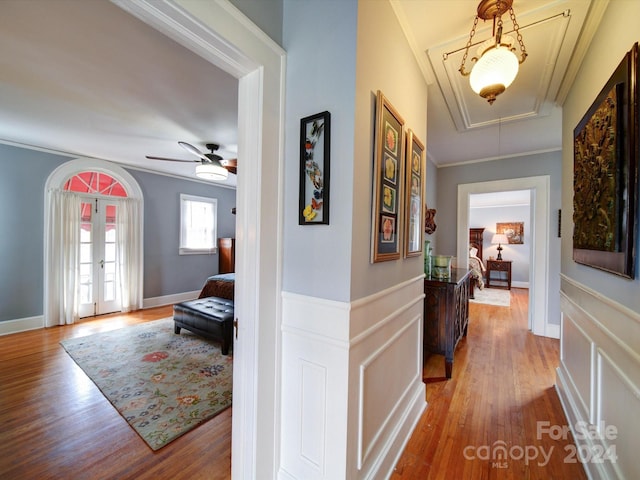 hallway featuring ornamental molding and light hardwood / wood-style floors