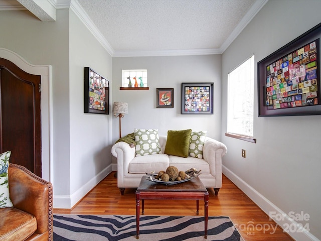 sitting room with a textured ceiling, ornamental molding, and light hardwood / wood-style flooring