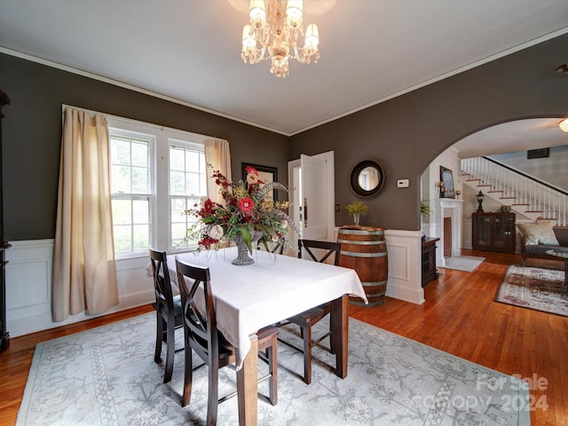 dining area featuring a chandelier, crown molding, and light hardwood / wood-style flooring