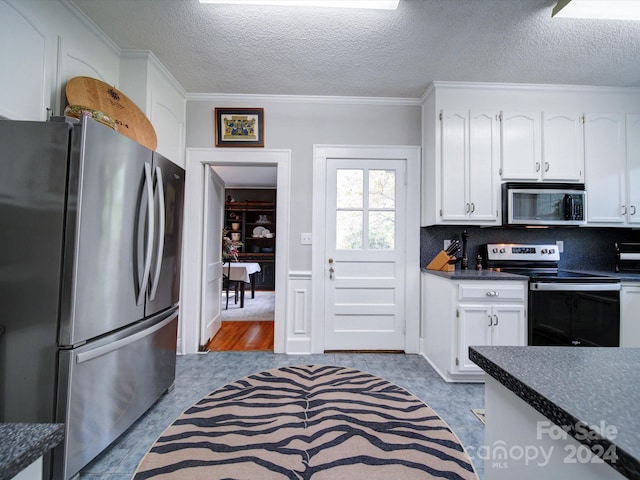 kitchen with appliances with stainless steel finishes, ornamental molding, a textured ceiling, light hardwood / wood-style flooring, and white cabinets