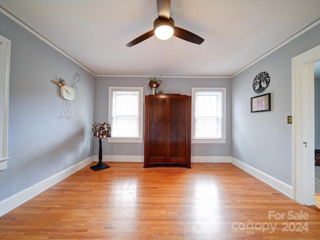 interior space with crown molding, a wealth of natural light, light hardwood / wood-style floors, and ceiling fan