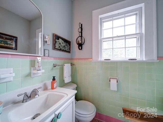 bathroom with tile walls, vanity, and toilet