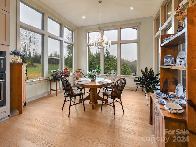 sunroom / solarium featuring plenty of natural light and a chandelier