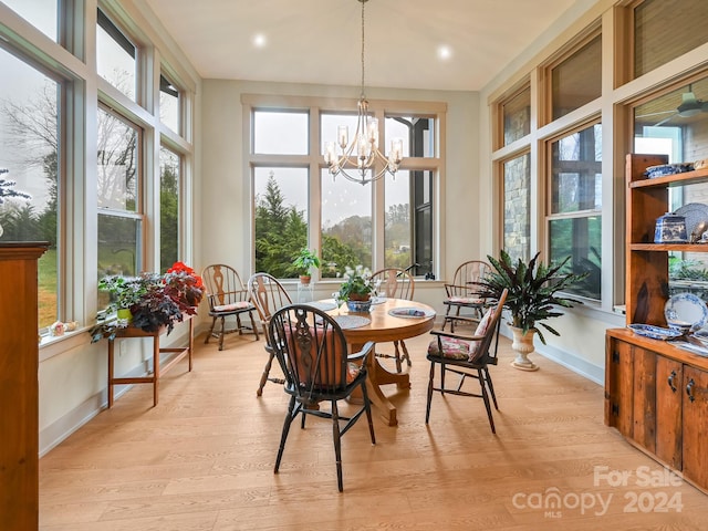 sunroom / solarium with a wealth of natural light and a notable chandelier