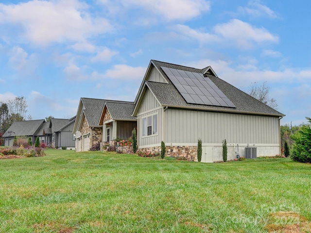 view of home's exterior with solar panels, a garage, central AC, and a yard