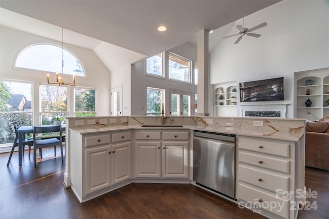 kitchen with a wealth of natural light, white cabinets, stainless steel dishwasher, and decorative light fixtures