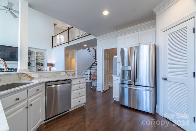 kitchen with appliances with stainless steel finishes, dark hardwood / wood-style flooring, white cabinetry, and light stone counters