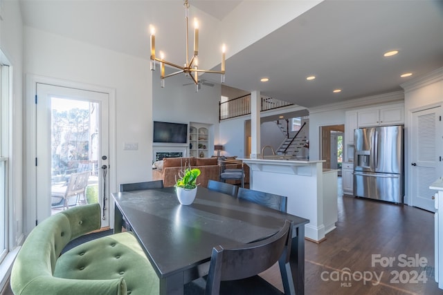 dining area featuring a wealth of natural light, crown molding, a chandelier, and dark hardwood / wood-style flooring