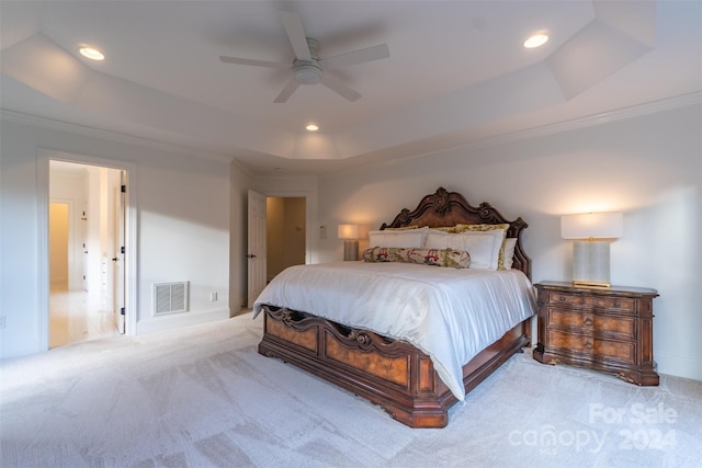 bedroom featuring light colored carpet, a raised ceiling, and ceiling fan