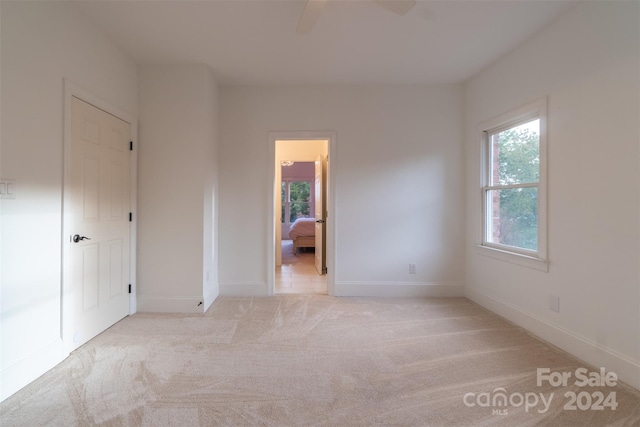 empty room with ceiling fan and light colored carpet