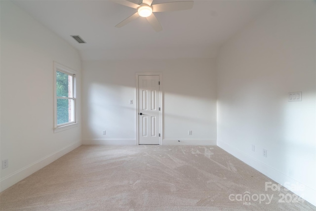 carpeted empty room featuring vaulted ceiling and ceiling fan