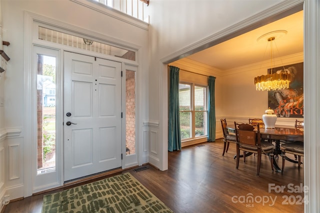 entrance foyer featuring a wealth of natural light, crown molding, and dark hardwood / wood-style flooring