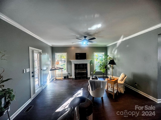 living room with ornamental molding, a fireplace, dark hardwood / wood-style flooring, and ceiling fan