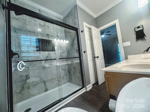 bathroom featuring wood-type flooring, vanity, an enclosed shower, crown molding, and toilet