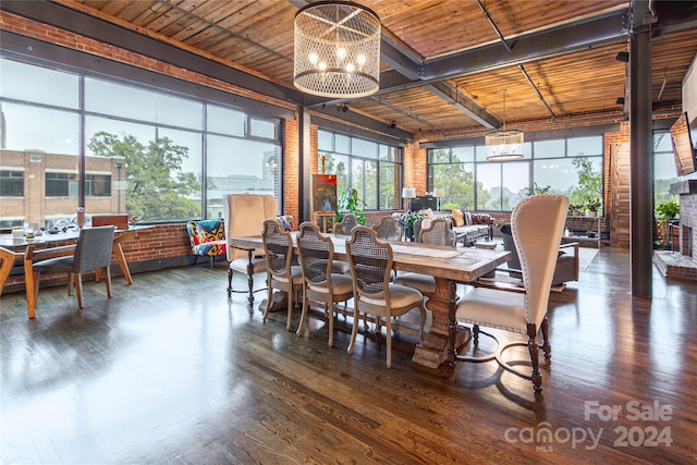 dining room with dark hardwood / wood-style flooring, an inviting chandelier, wooden ceiling, and a brick fireplace