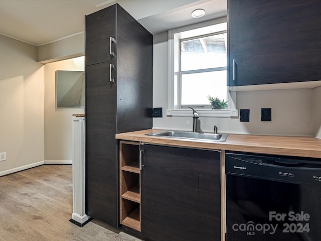 kitchen featuring butcher block countertops, sink, black dishwasher, and light hardwood / wood-style flooring