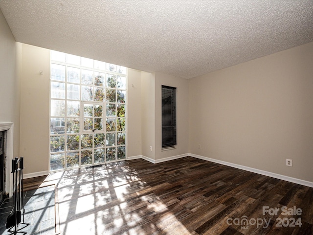 unfurnished room featuring dark hardwood / wood-style flooring and a textured ceiling