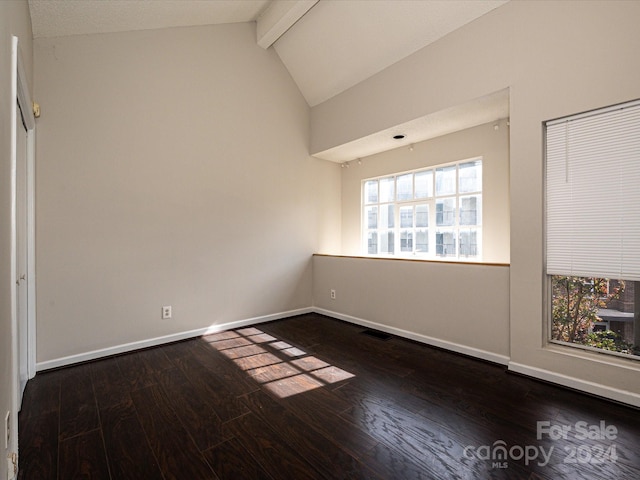 spare room with dark wood-type flooring and lofted ceiling with beams