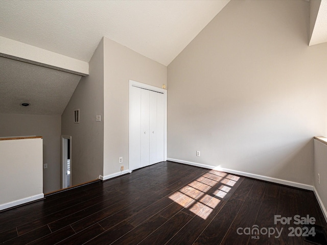 interior space with hardwood / wood-style flooring, a textured ceiling, and high vaulted ceiling