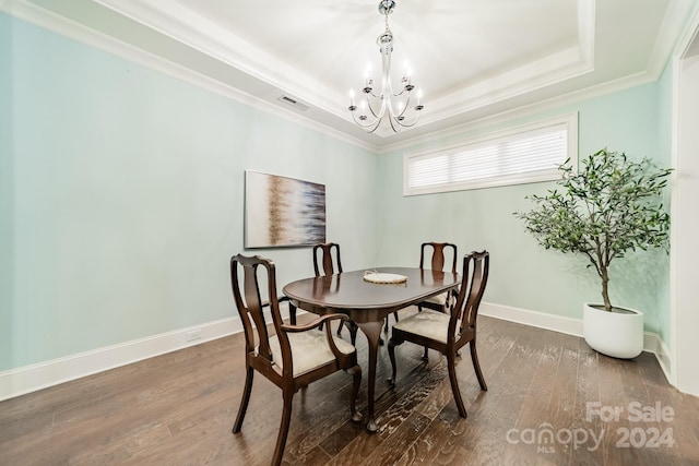 dining area featuring ornamental molding, a notable chandelier, a tray ceiling, and dark hardwood / wood-style flooring