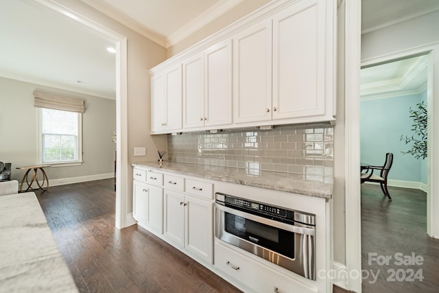 kitchen with light stone countertops, dark hardwood / wood-style flooring, white cabinetry, and stainless steel oven