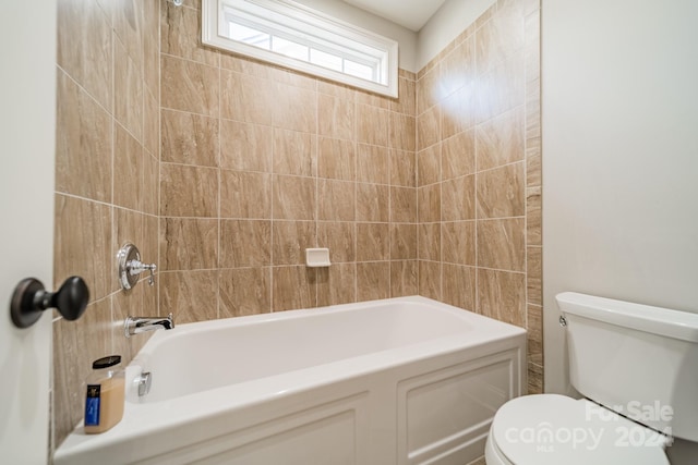 bathroom featuring toilet and tiled shower / bath