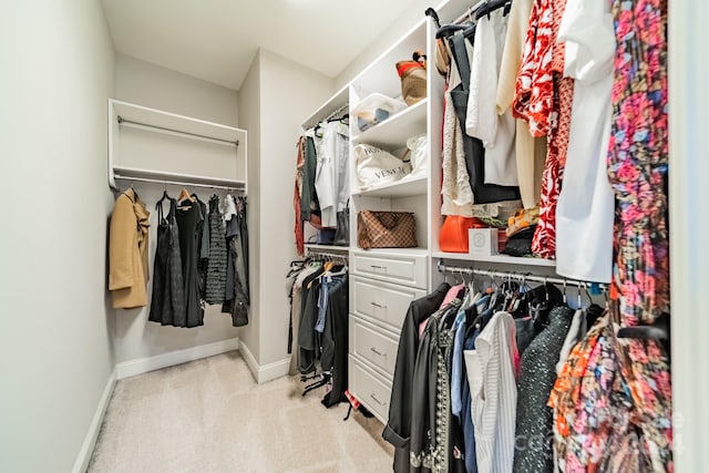 walk in closet featuring light carpet