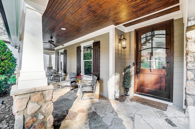 view of exterior entry featuring ceiling fan and a porch