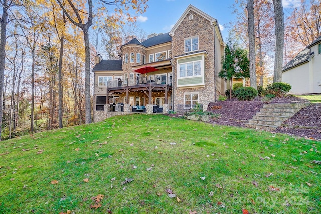 rear view of property with a wooden deck and a yard