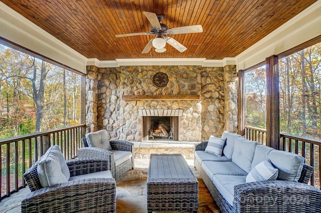 sunroom / solarium with an outdoor stone fireplace, ceiling fan, and wood ceiling