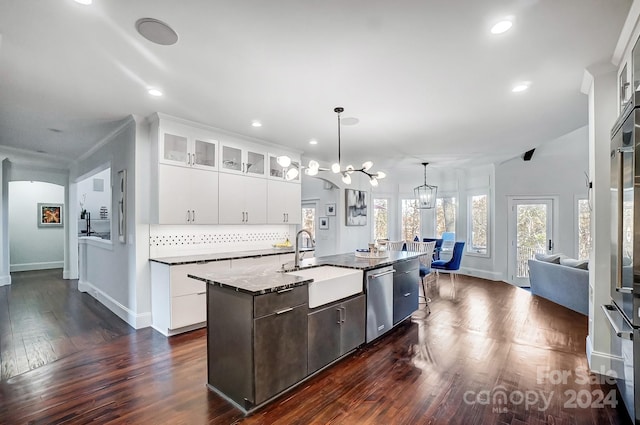 kitchen featuring white cabinets, dark hardwood / wood-style flooring, a center island with sink, and sink