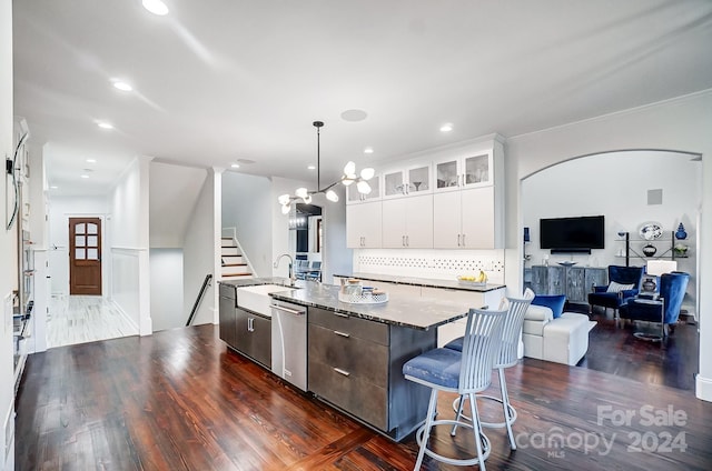 kitchen with white cabinetry, sink, dark wood-type flooring, stainless steel dishwasher, and an island with sink