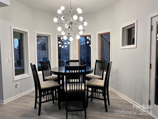 dining area featuring hardwood / wood-style flooring, vaulted ceiling, and a notable chandelier