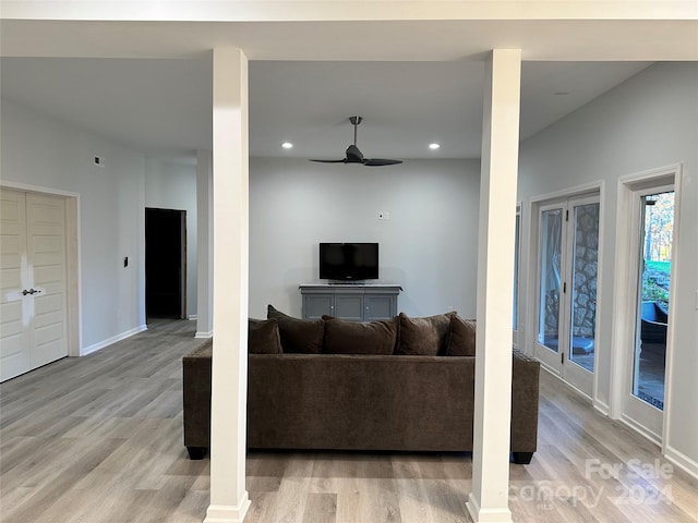 living room with light wood-type flooring and ceiling fan