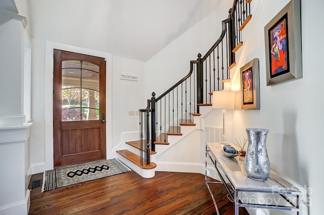 entryway featuring stairs, dark wood-type flooring, and baseboards