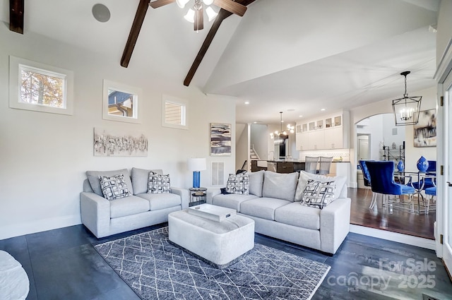 living area featuring high vaulted ceiling, ceiling fan with notable chandelier, arched walkways, baseboards, and beam ceiling