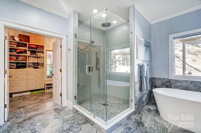 bathroom featuring a shower stall, a spacious closet, a freestanding tub, marble finish floor, and ornamental molding