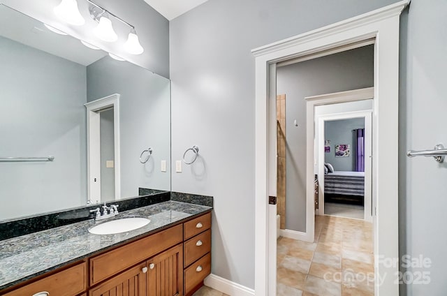ensuite bathroom featuring baseboards, ensuite bath, vanity, and tile patterned floors