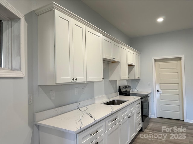 kitchen featuring white cabinets, stainless steel electric range, wood finished floors, and recessed lighting