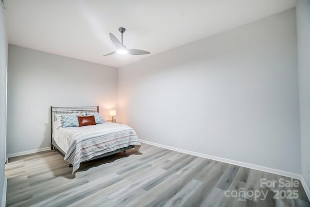 bedroom with wood finished floors, a ceiling fan, and baseboards