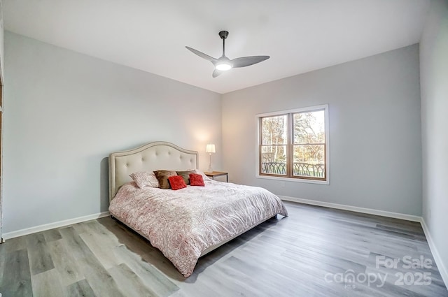 bedroom with wood finished floors, baseboards, and ceiling fan