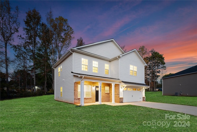 view of front of property featuring covered porch, a garage, a yard, and central AC